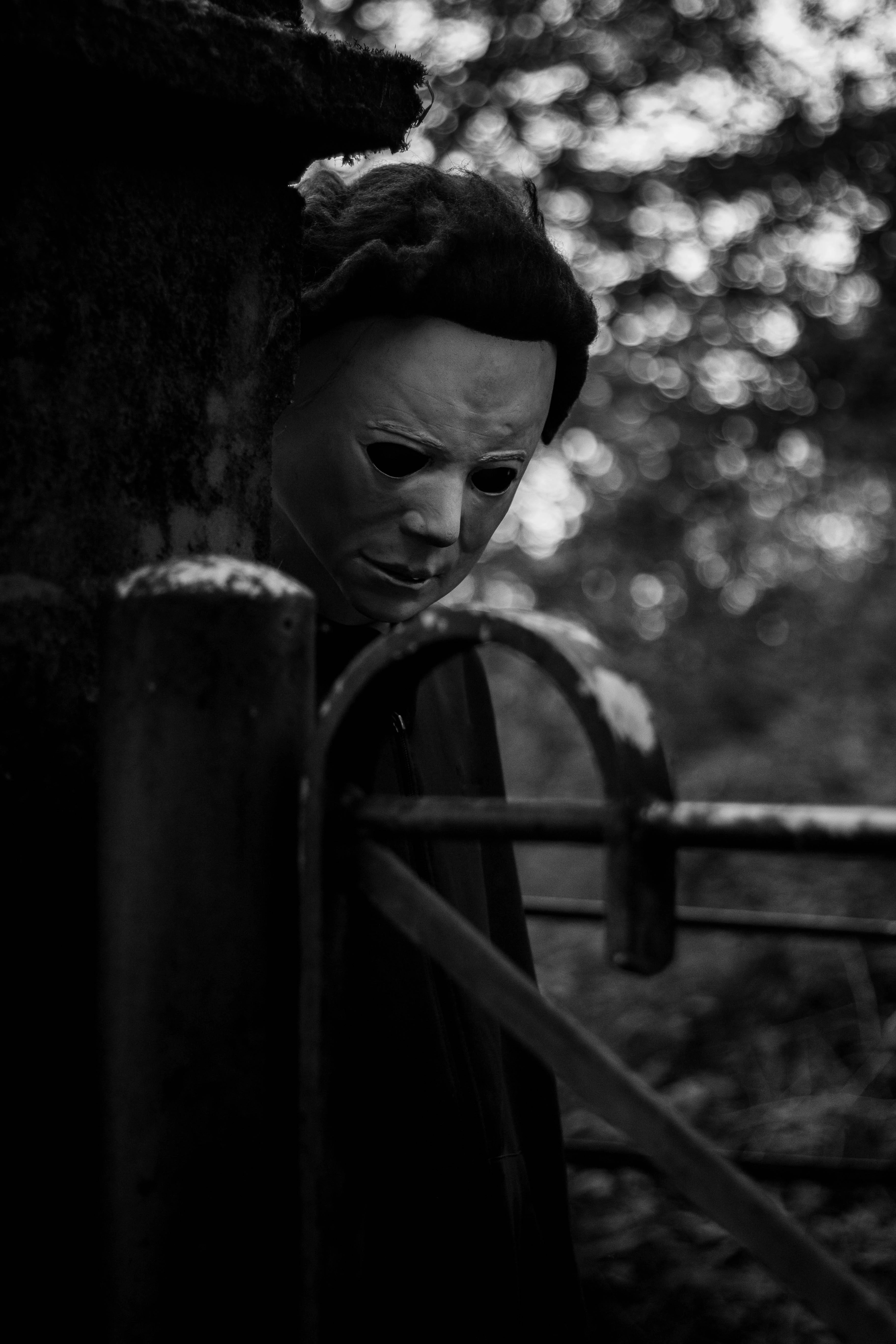 Michael Myers behind a gate pillar
